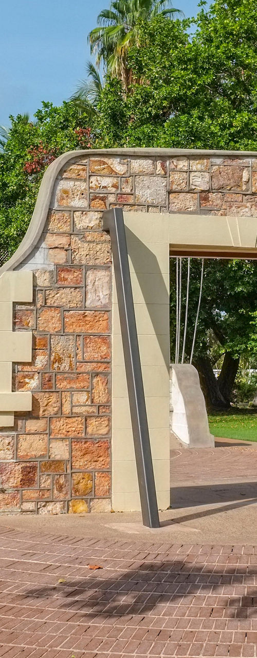 Historic stone archway in lush park setting