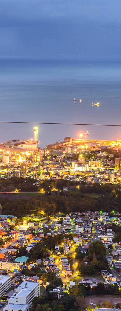 Cityscape with illuminated harbor at dusk
