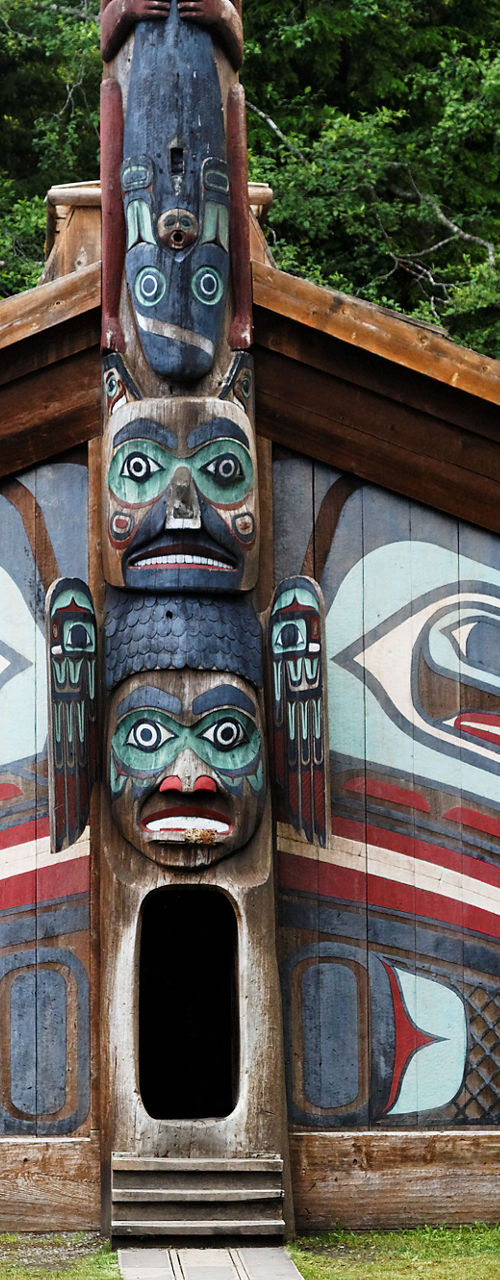 Traditional wooden totem poles and tribal house