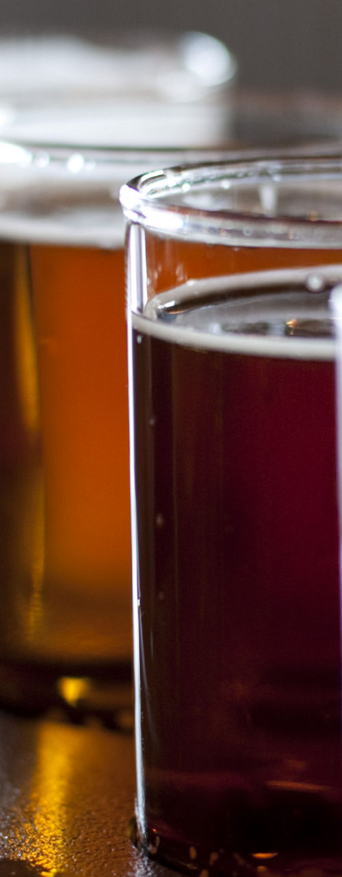 Assorted craft beer glasses on wooden tray