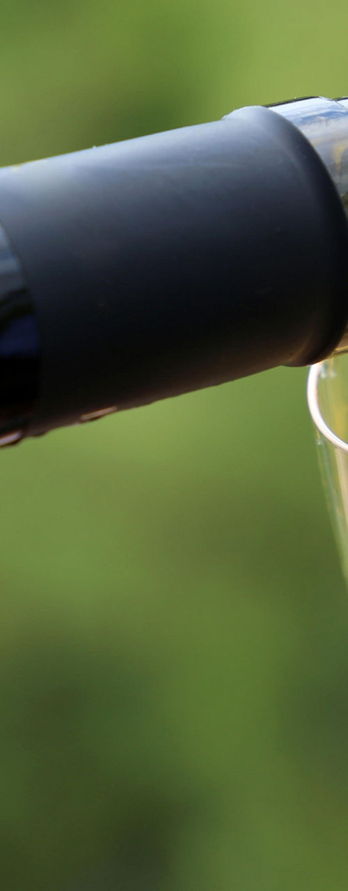 Pouring white wine into glass outdoors