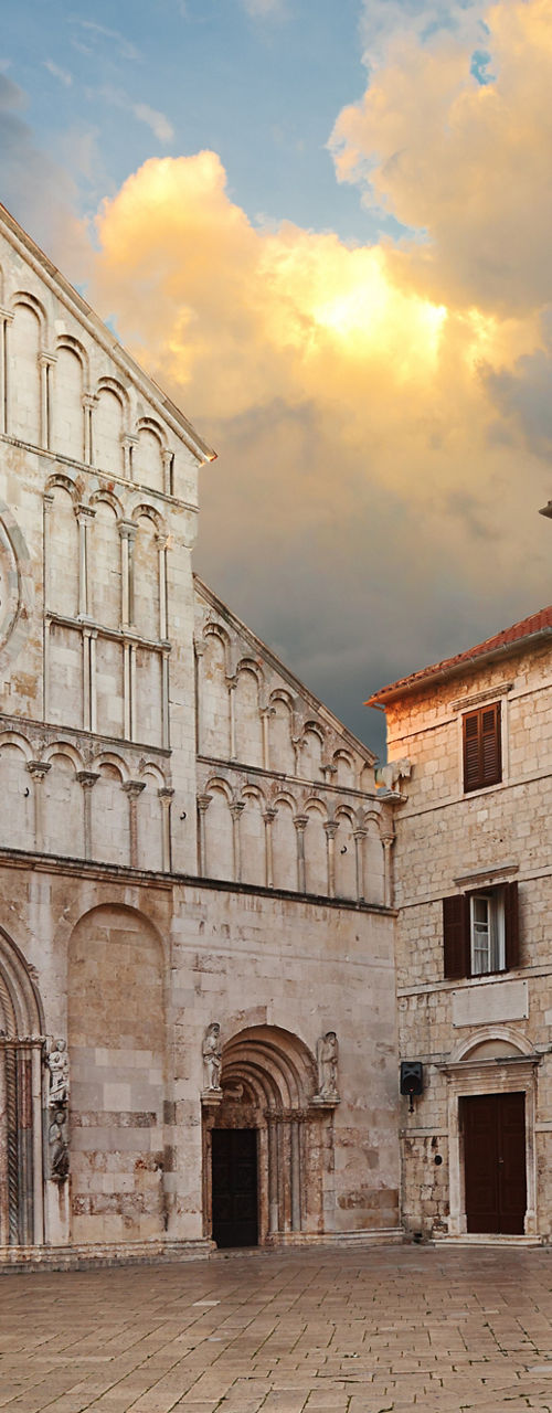 Historic cathedral and stone buildings at sunset
