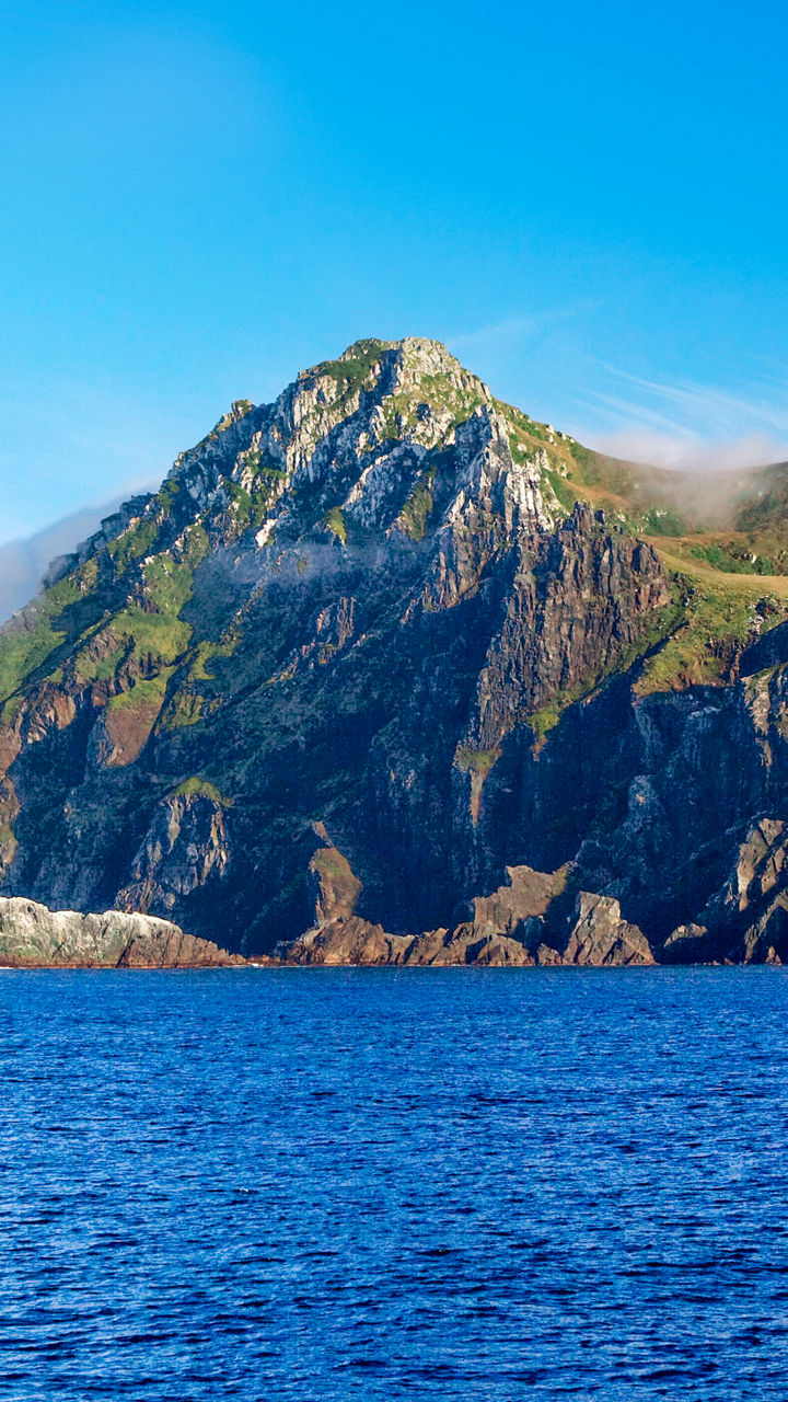 Majestic coastal mountain under clear skies