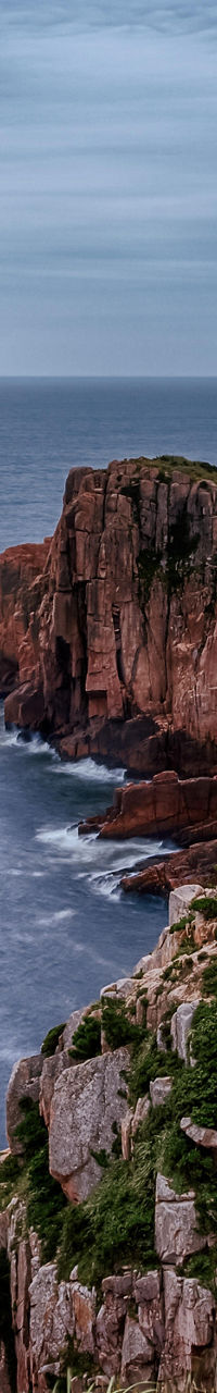 Dramatic coastal cliffs under cloudy sky