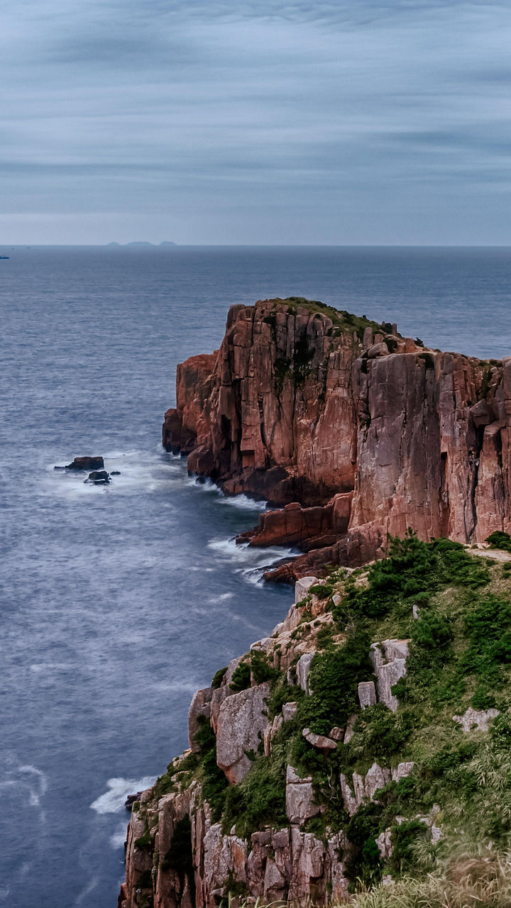 Dramatic coastal cliffs under cloudy sky