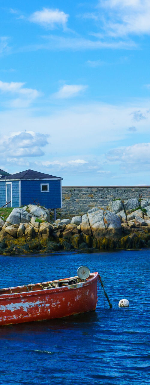 Coastal village with red boat and houses