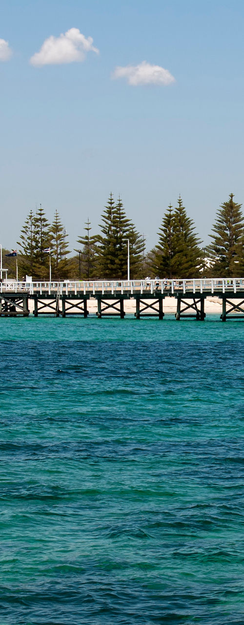 Coastal pier extending over turquoise sea