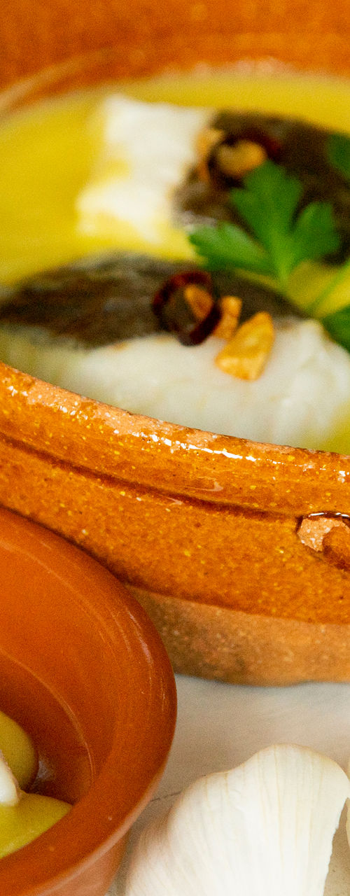 Traditional cod with garlic sauce in rustic bowls