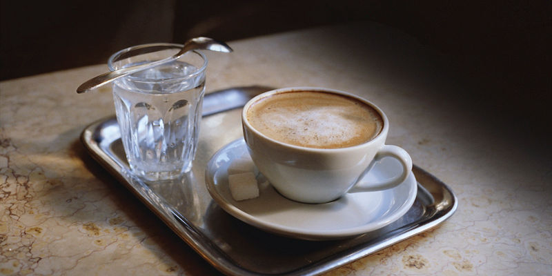 Cup of coffee with water on tray