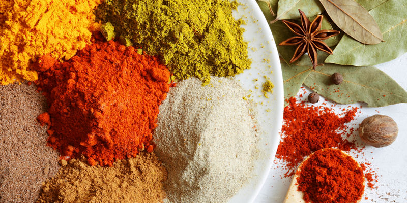 Assorted colorful spices on white plate