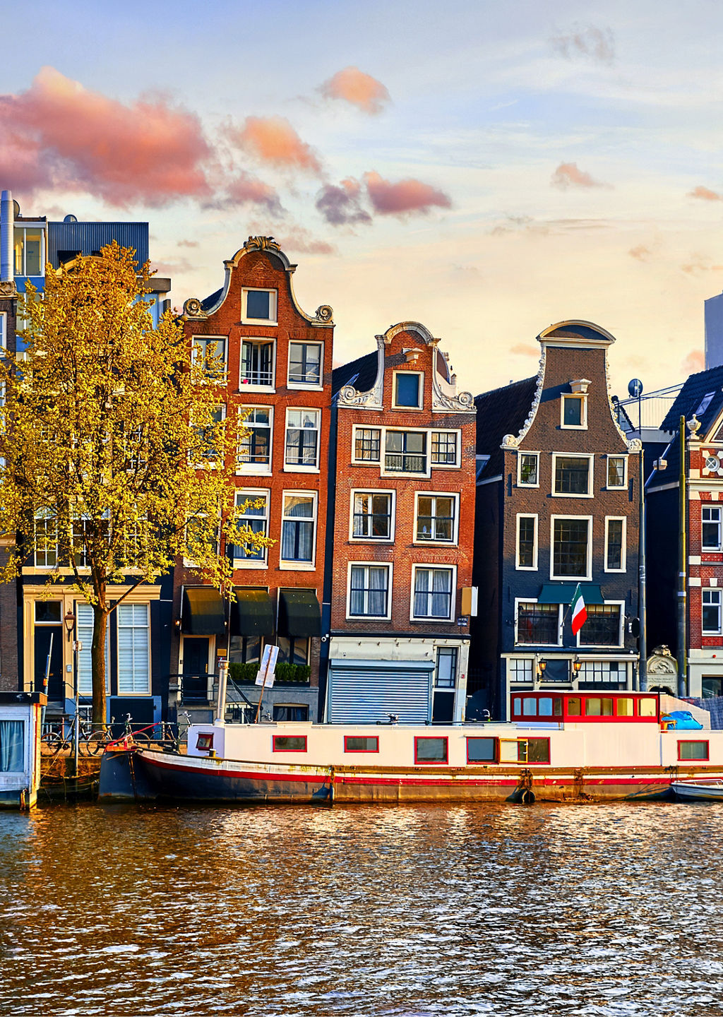 Colorful canal houses in Amsterdam at sunset
