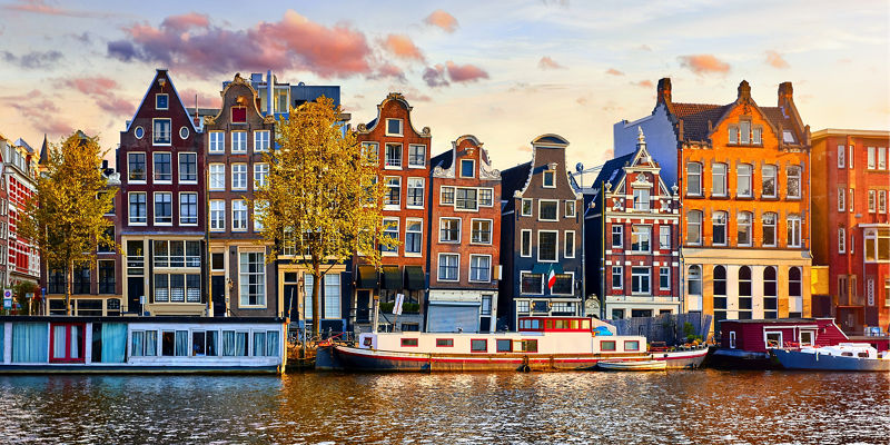 Colorful canal houses in Amsterdam at sunset