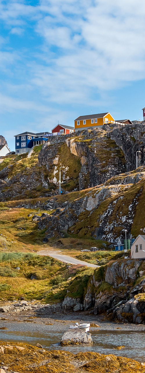 Colorful houses on rocky hillside under blue sky