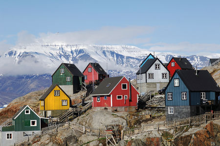 Colorful houses on rocky hillside with snowy mountains