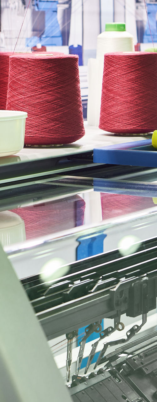 Industrial knitting machine with colorful yarn spools