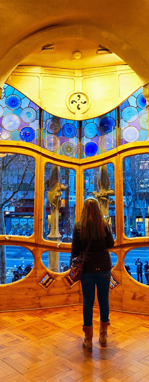 Woman admiring stained glass in ornate room