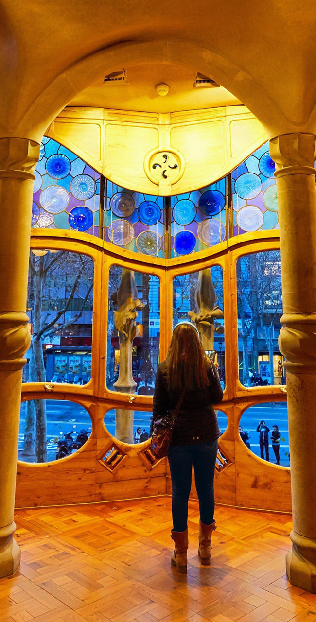 Woman admiring stained glass in ornate room