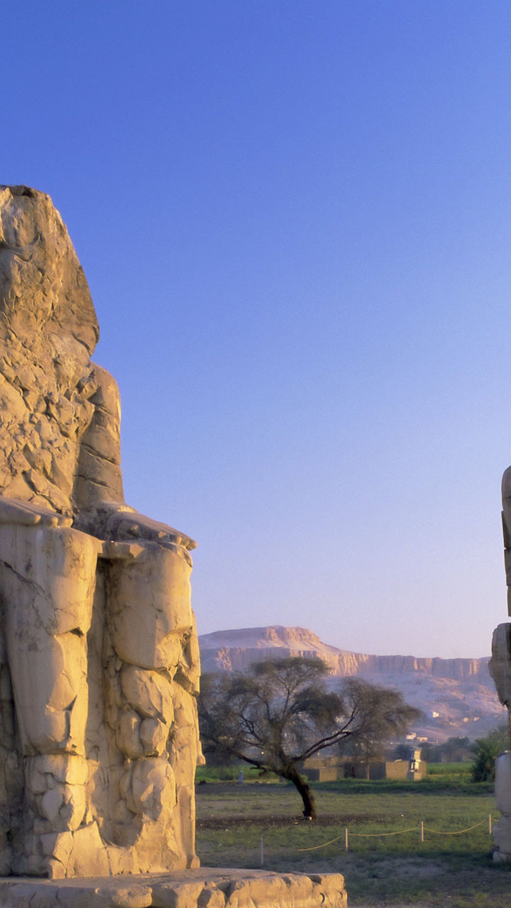 Ancient Colossi statues in Egyptian landscape