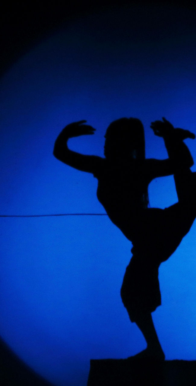 Silhouette of dancer in blue spotlight