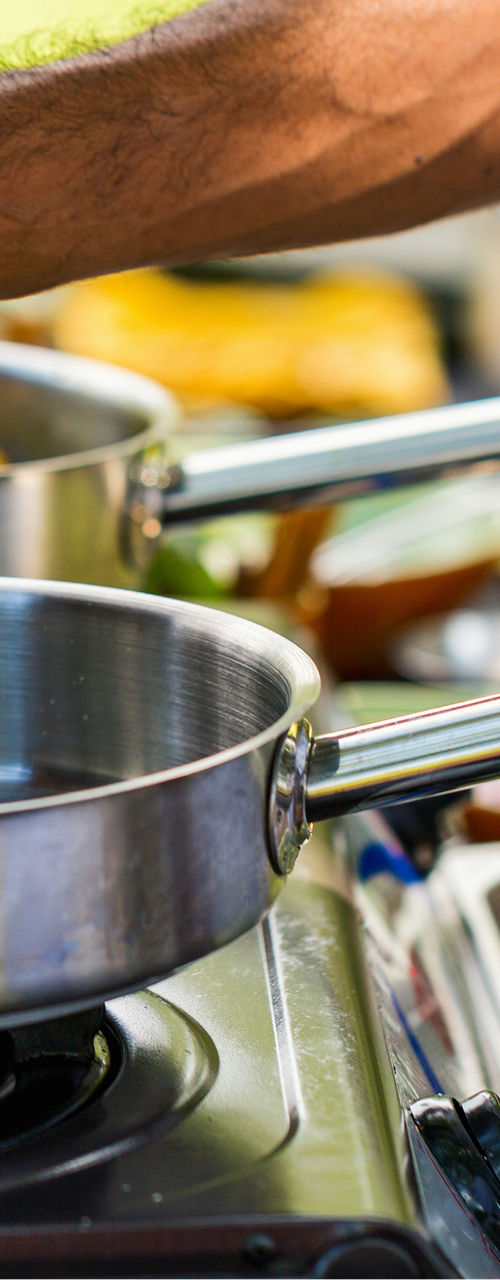Chef seasoning pan at outdoor cooking station