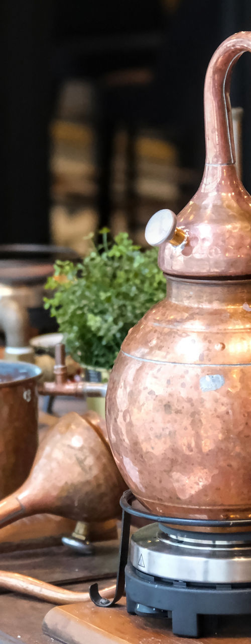 Copper distillation setup with herbs and glassware