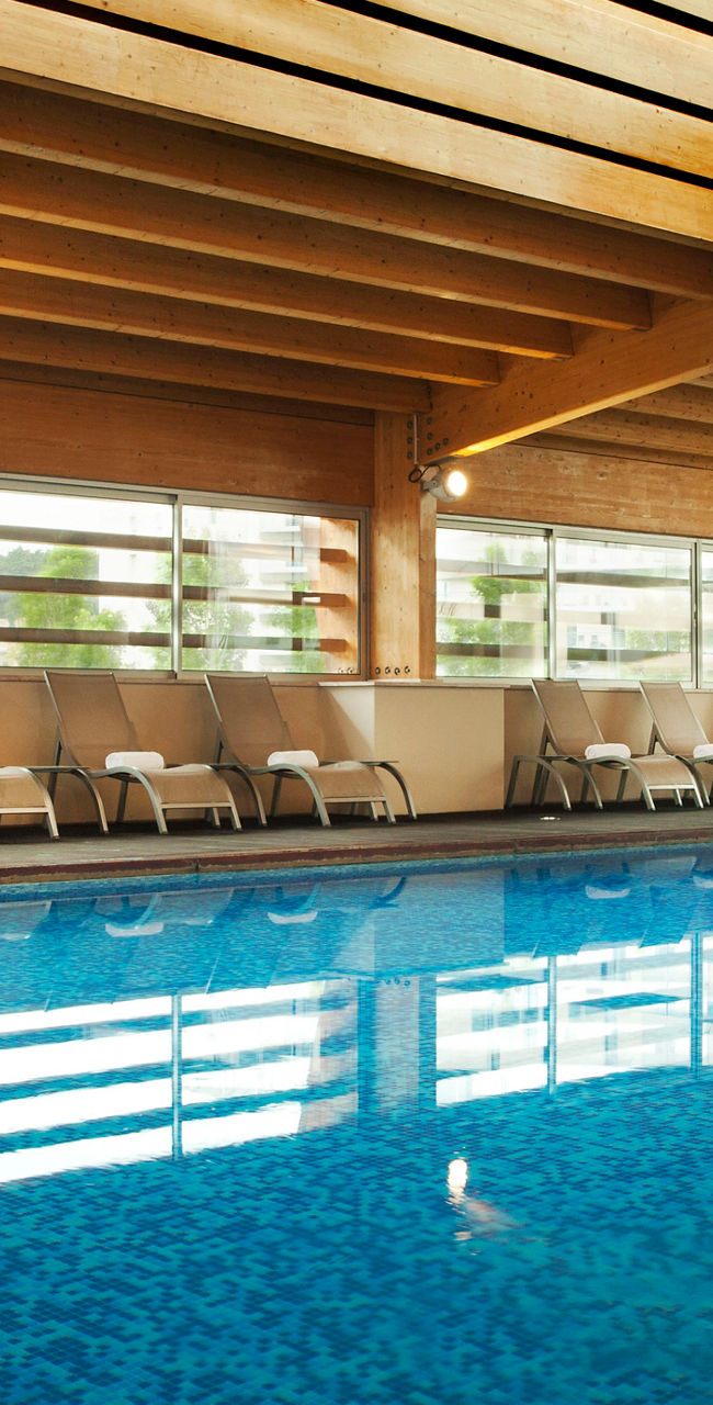 Indoor swimming pool with wooden ceiling