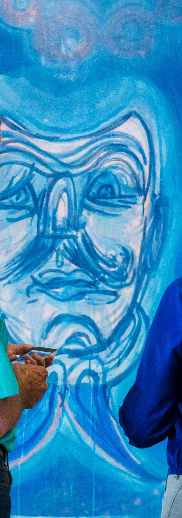 Two visitors viewing abstract blue artwork