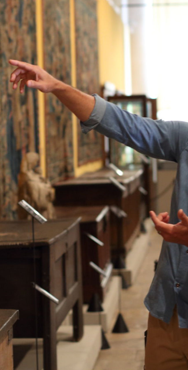 Visitors admiring tapestries in museum
