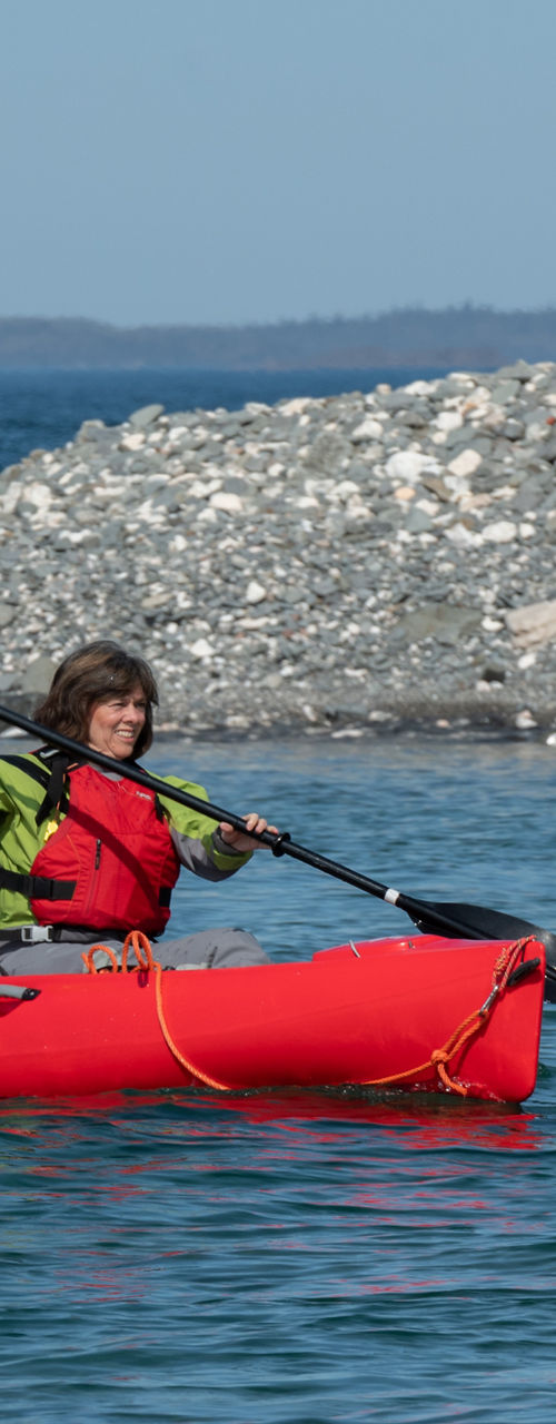 Two people kayaking in red tandem kayak