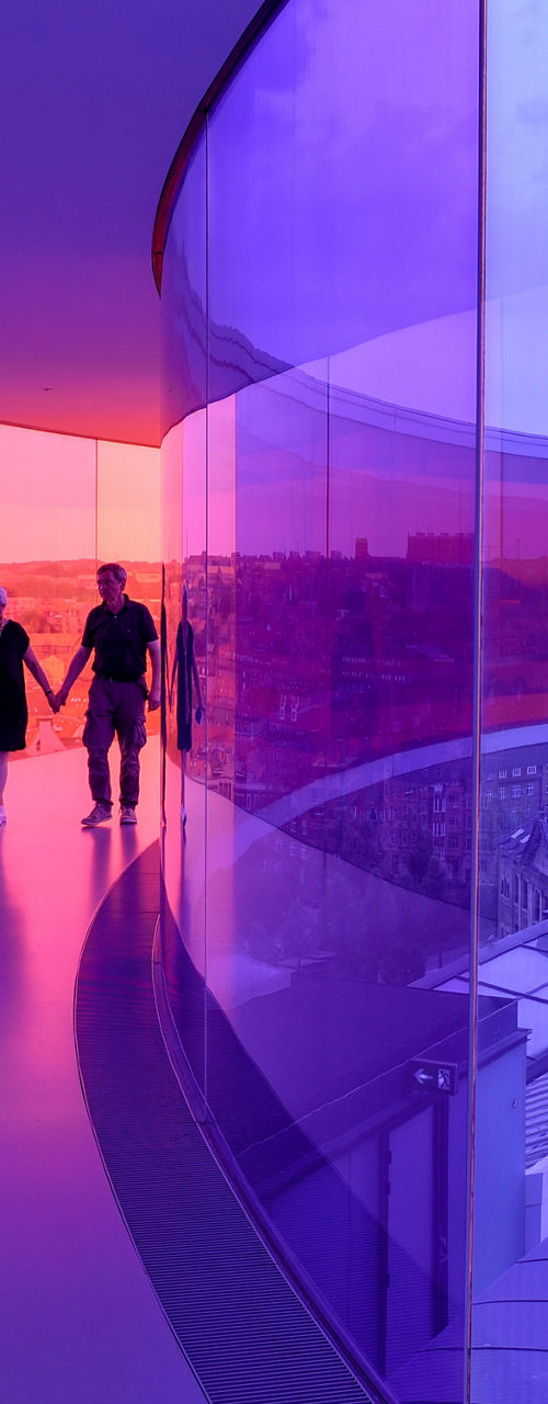 Couple walking in colorful glass corridor