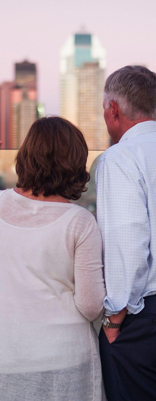 Couple admiring city skyline at sunset