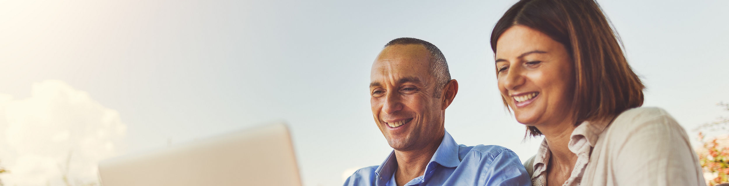 Couple working outdoors on laptop