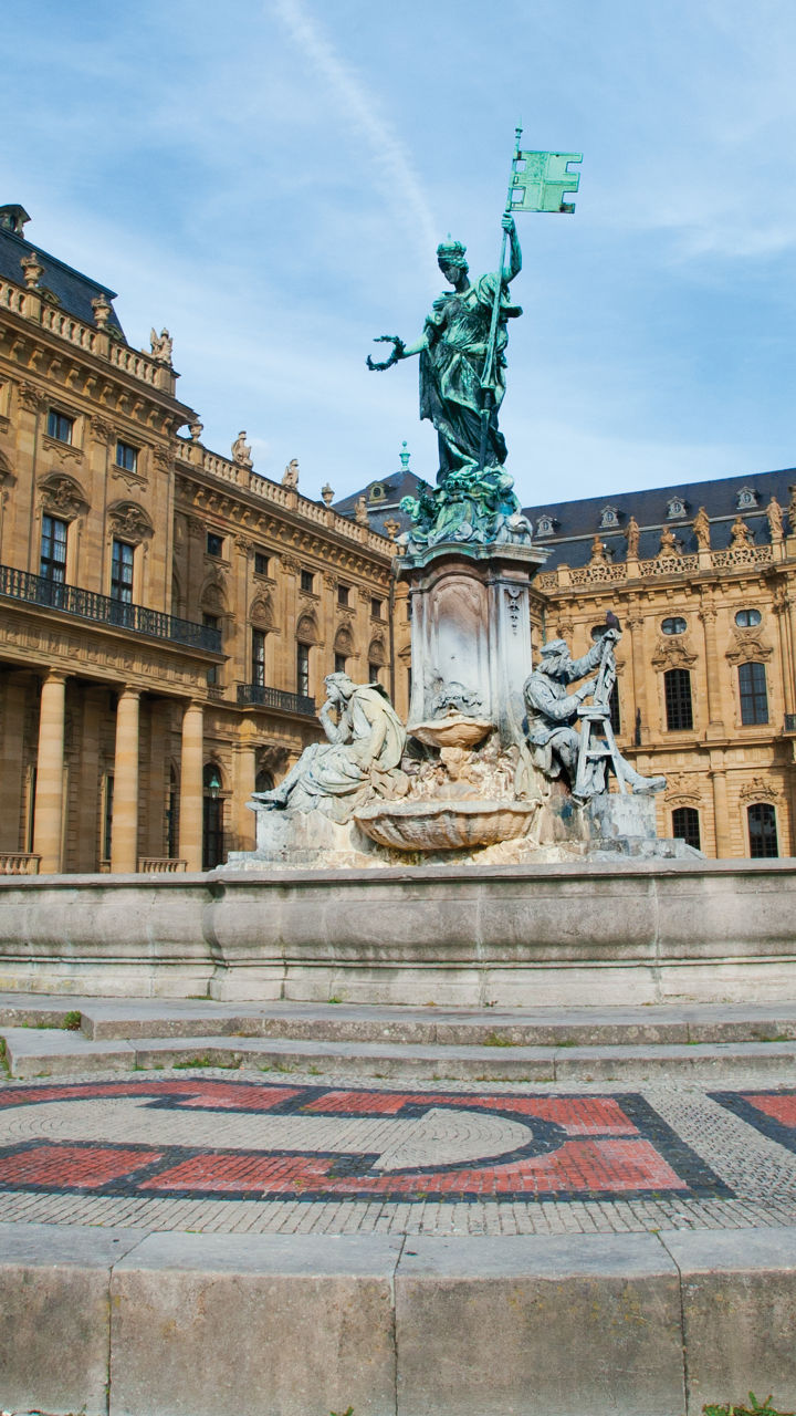 Historic palace with central fountain statue