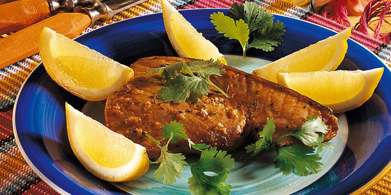 Grilled fish with lemon wedges and garnish