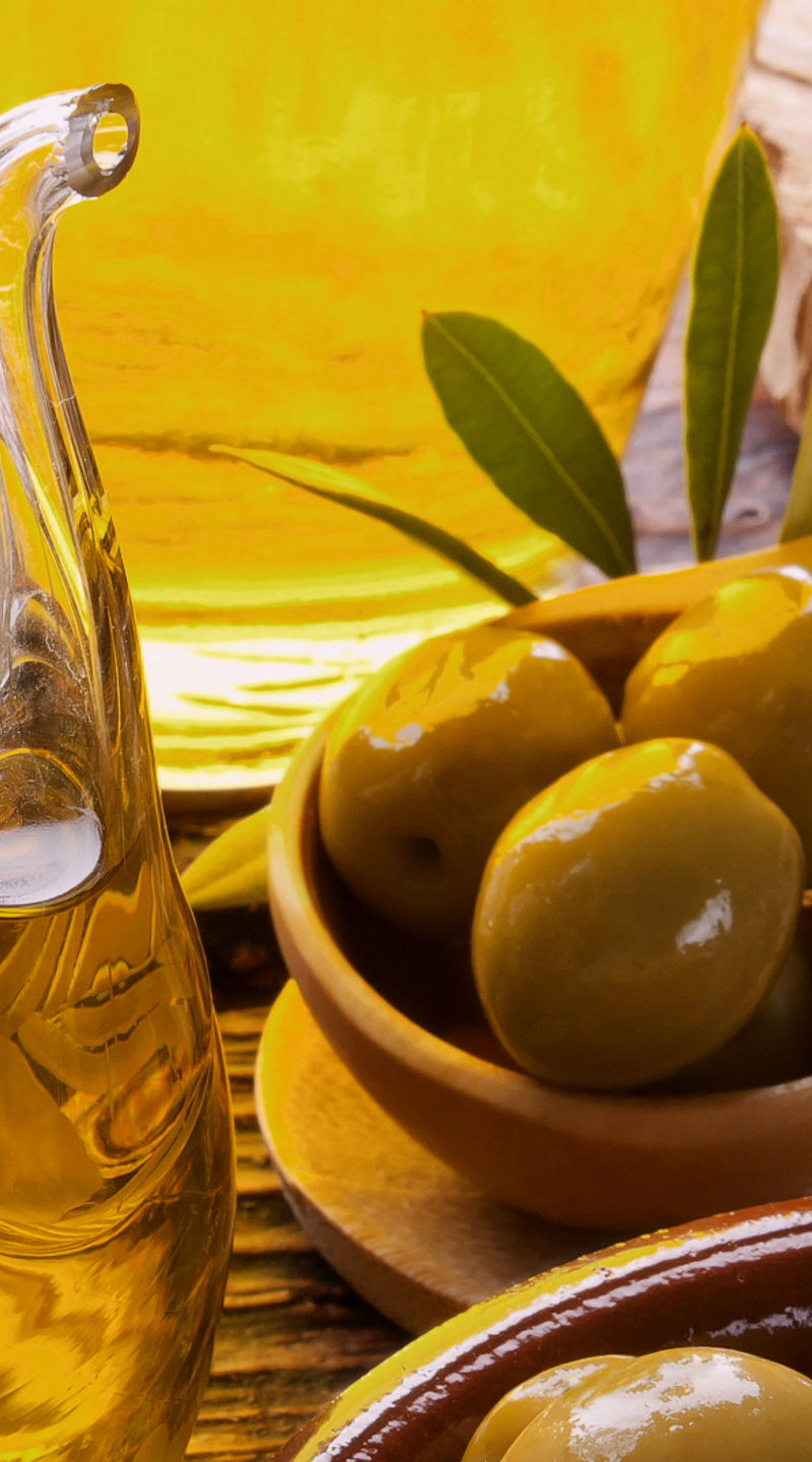 Fresh olives and olive oil in rustic setting