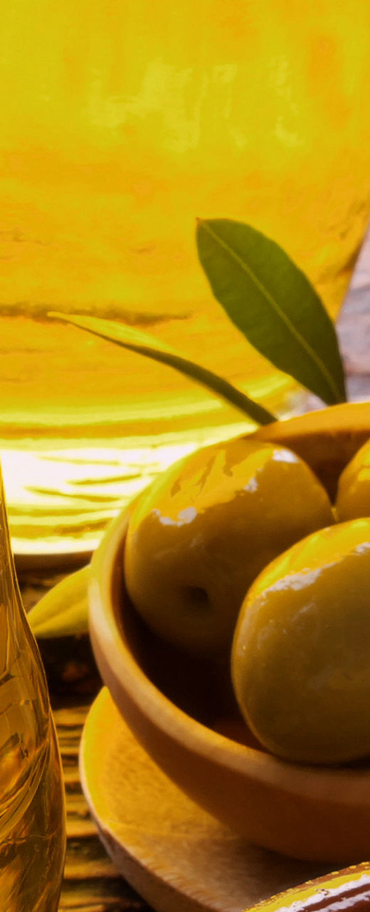 Fresh olives and olive oil in rustic setting