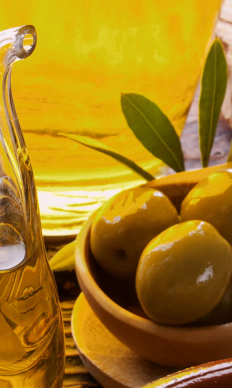 Fresh olives and olive oil in rustic setting
