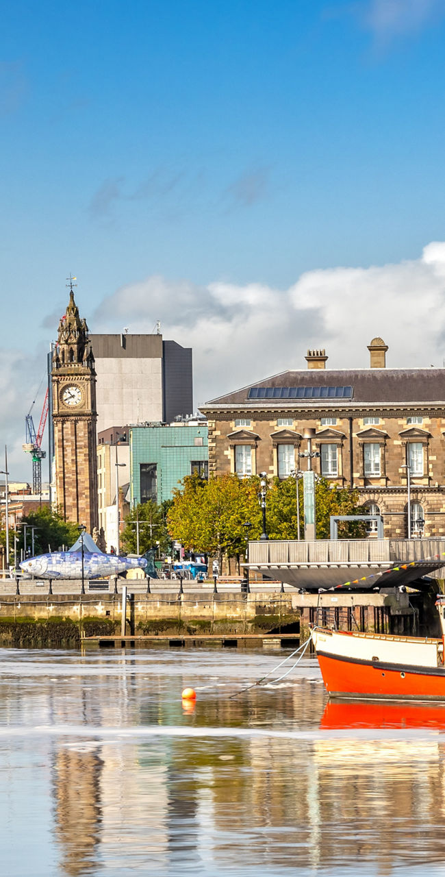 Red boat on Belfast waterfront cityscape