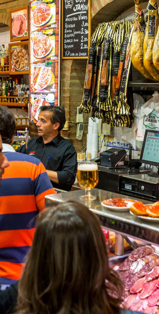 Busy deli with hanging cured meats