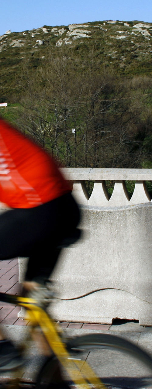 Cyclist near historic tower in daylight