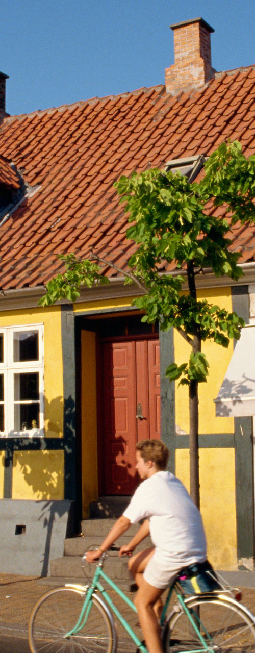 Cyclists passing colorful village storefronts