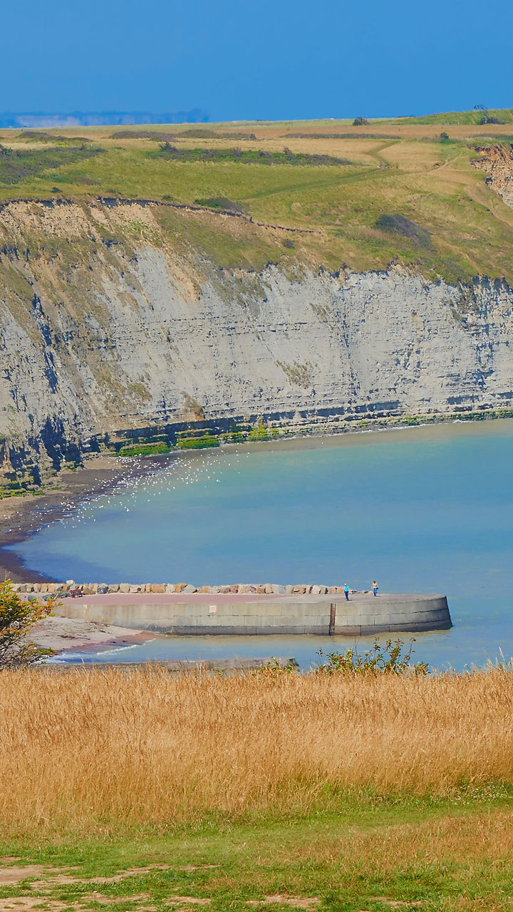 Coastal cliffside with walking tourists