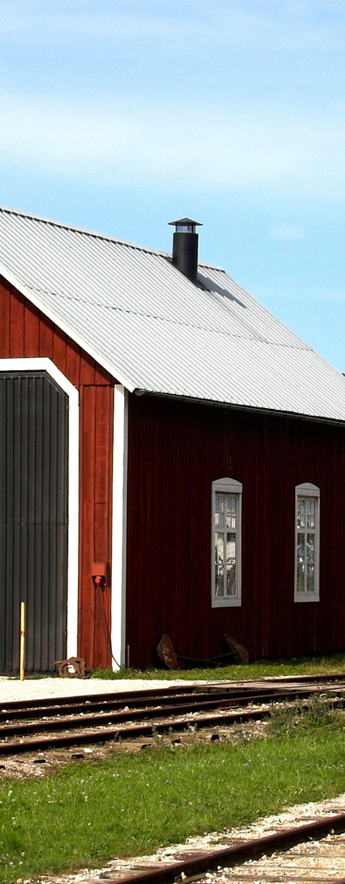 Red barn and vintage train car on tracks