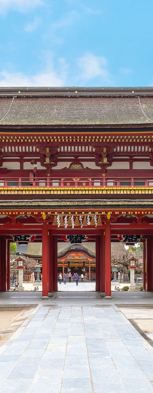 Traditional Japanese temple gate with stone lanterns