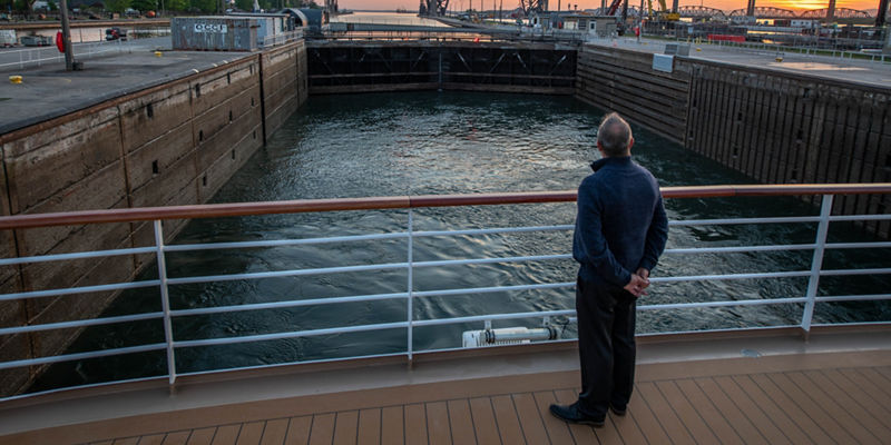 Man observing canal locks at sunset