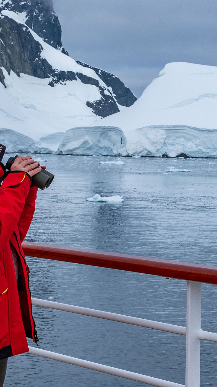 Person in red jacket photographing icy landscape