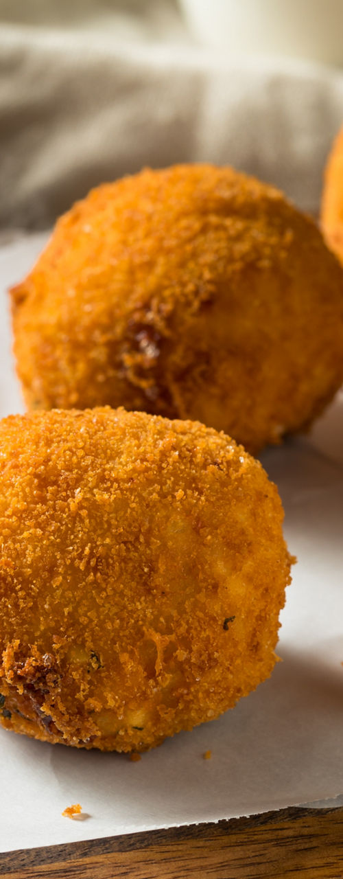 Golden crispy arancini with basil garnish