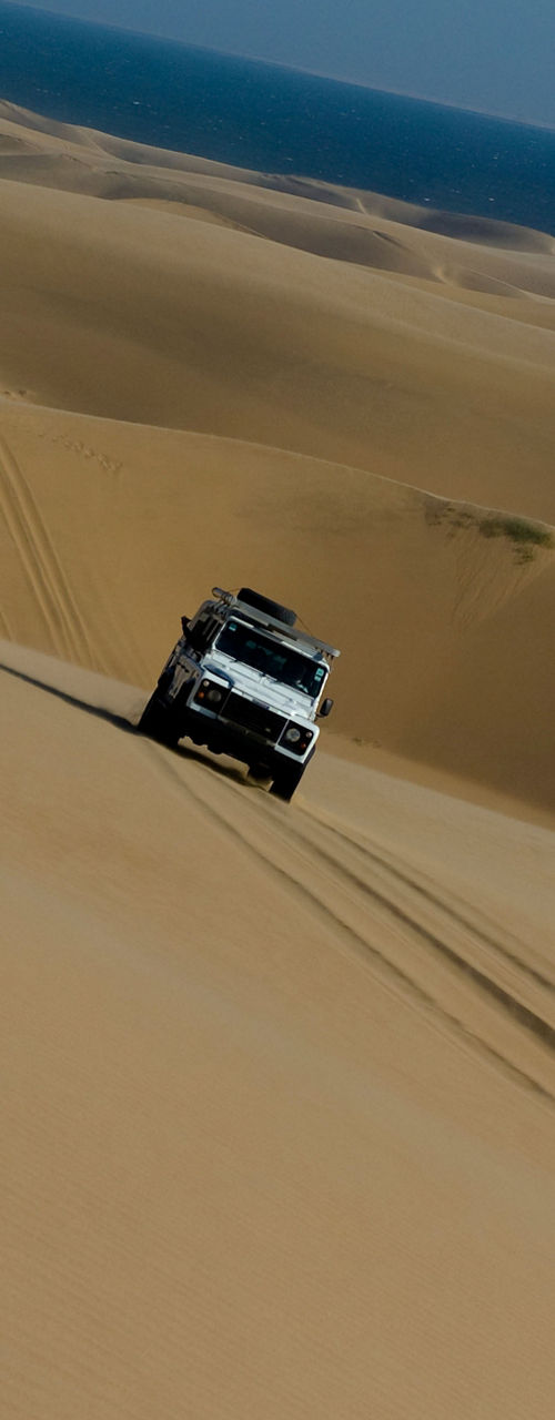 Off-road vehicle driving on desert dunes