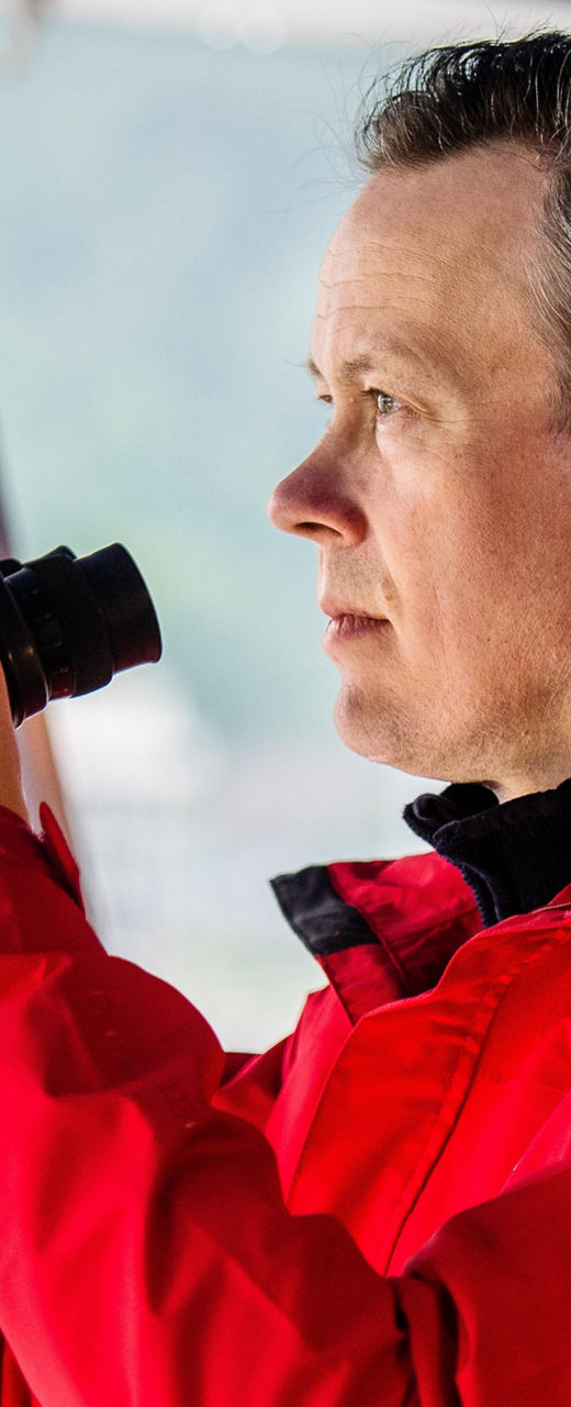 Man in red jacket using binoculars