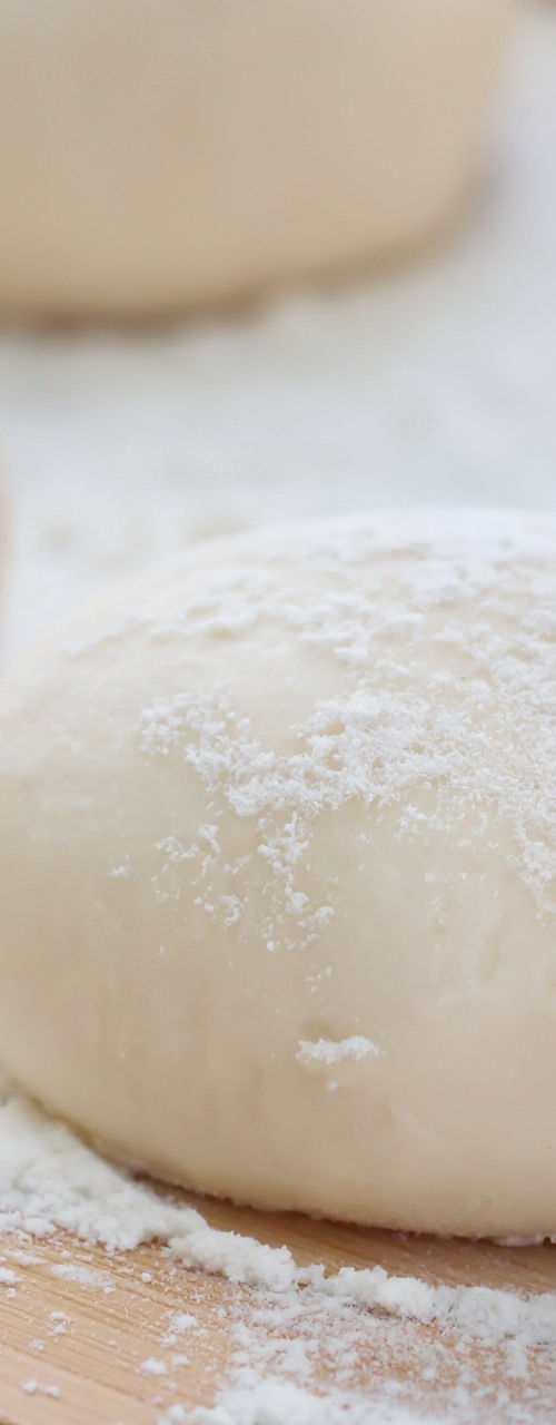 Freshly prepared dough balls on wooden surface